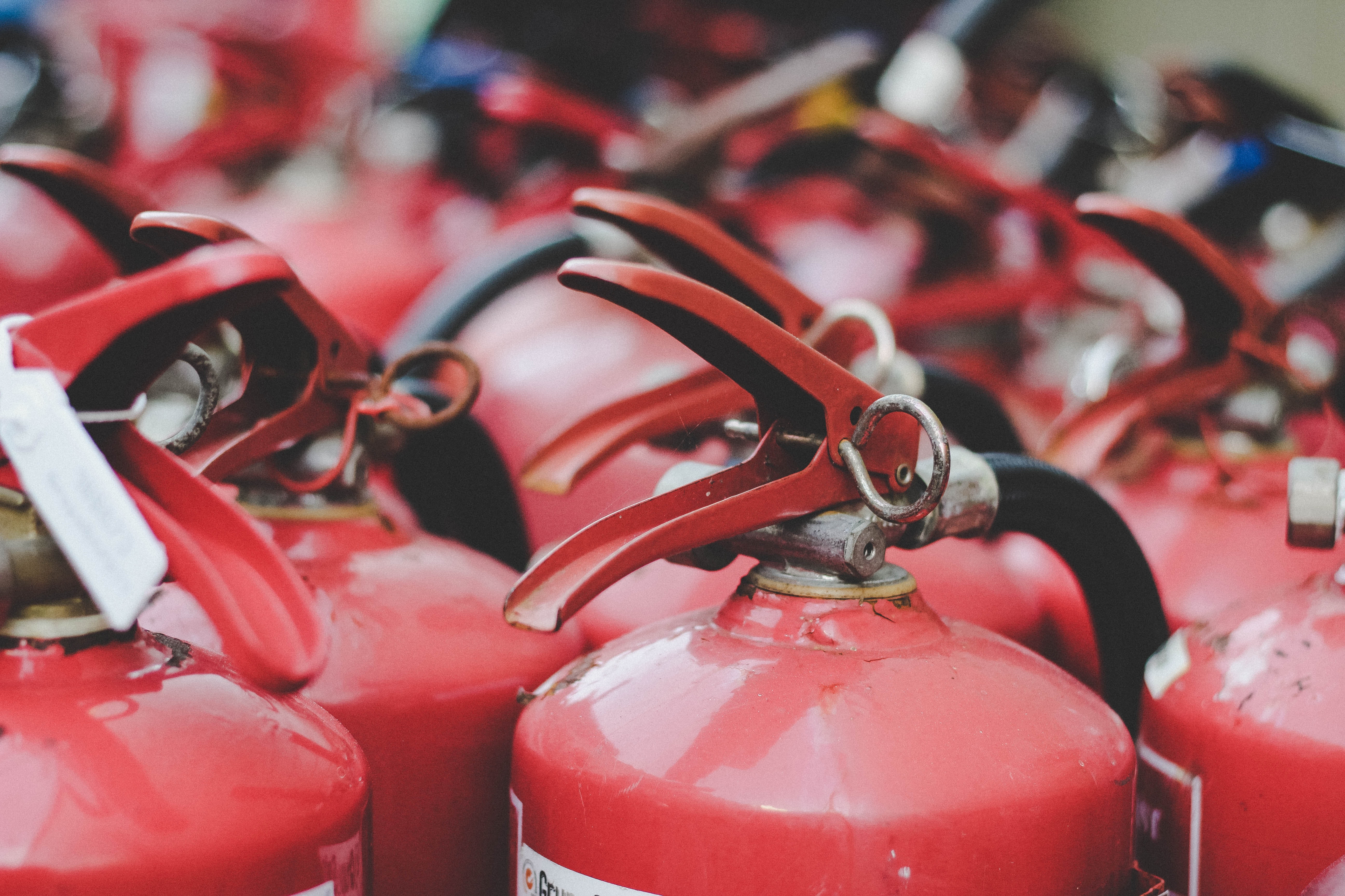 Boss Fire NFPA-certified technician inspecting and tagging a commercial fire extinguisher in the GTA