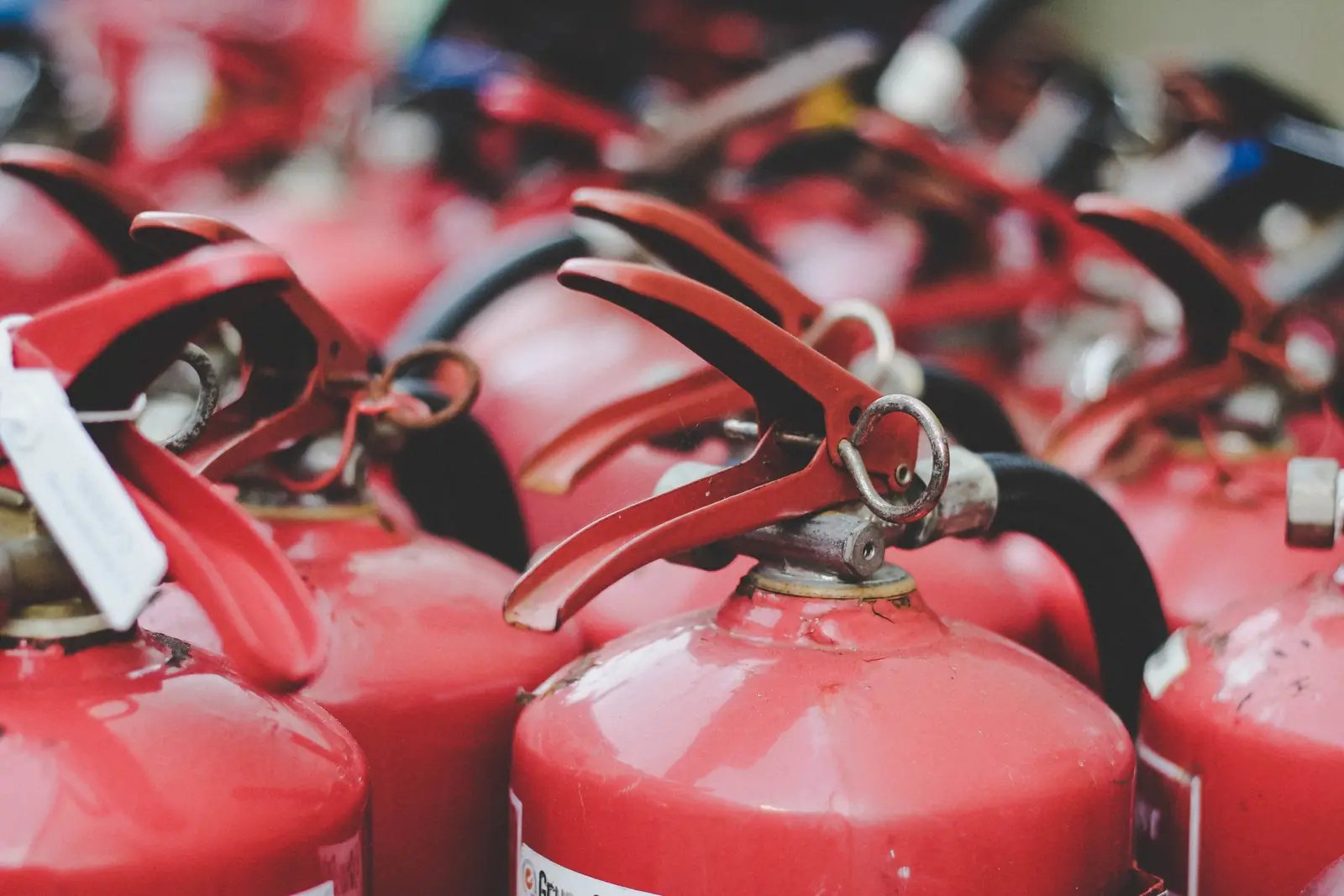 Boss Fire NFPA-certified technician inspecting and tagging a commercial fire extinguisher in the GTA
